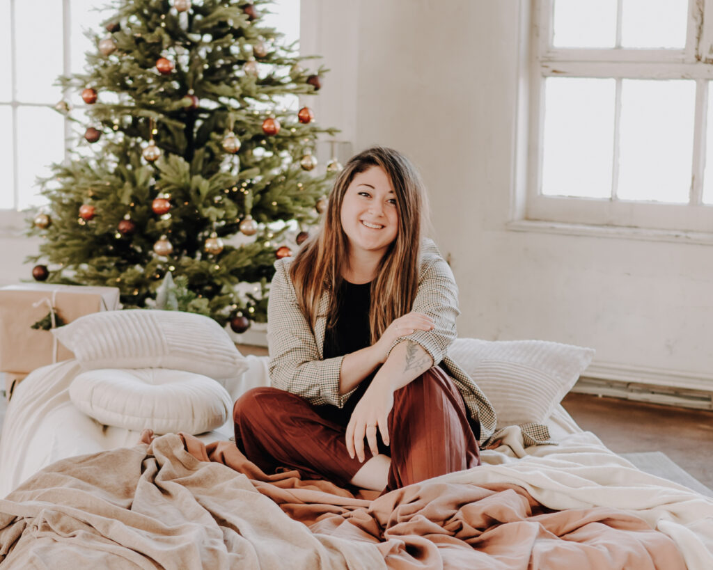 Florentina sitzt vor Weihnachtsbaum